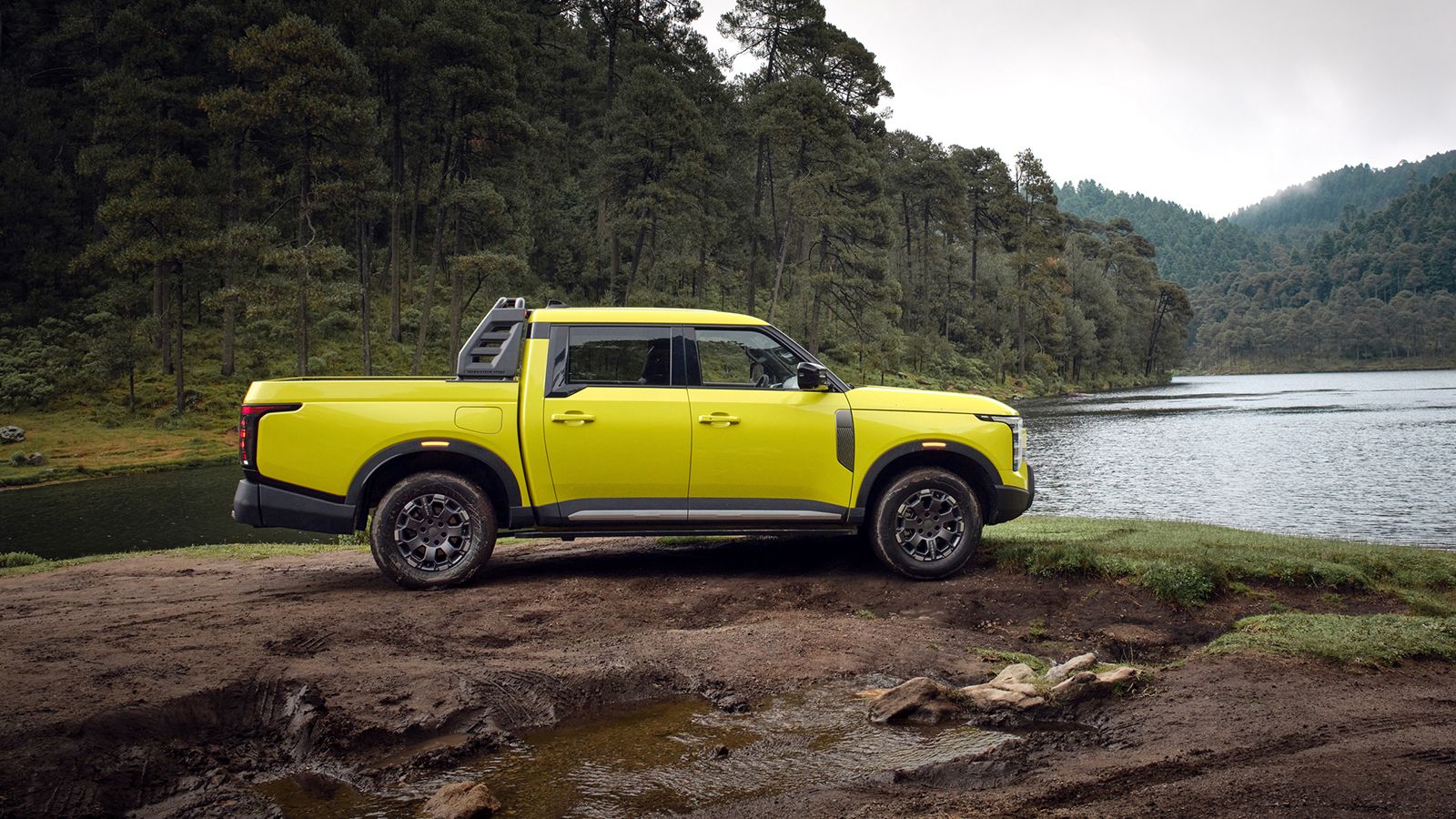Πλάγια όψη του διπλοκάμπινου Nissan Navara Pro σε χωμάτινο τοπίο δίπλα σε λίμνη.